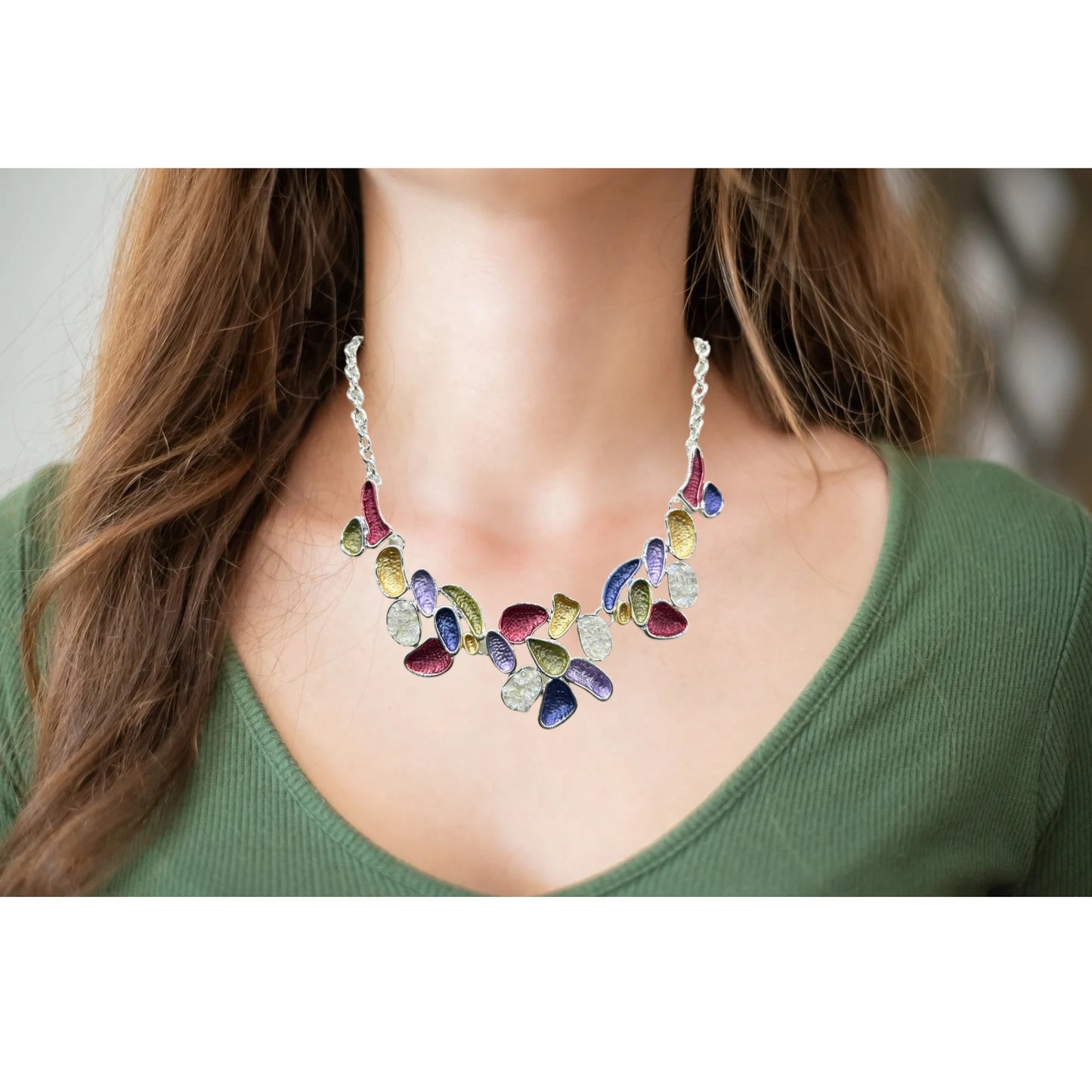 A vibrant multicolor statement necklace with purple, gold, red, and green enamel accents on an adjustable silver-tone chain