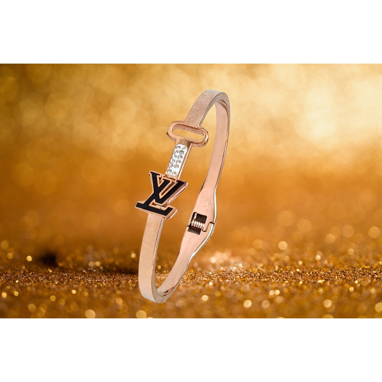 Close-up of a rose gold bracelet featuring a sleek key and initial design, with sparkling accents, perfect for stylish women.