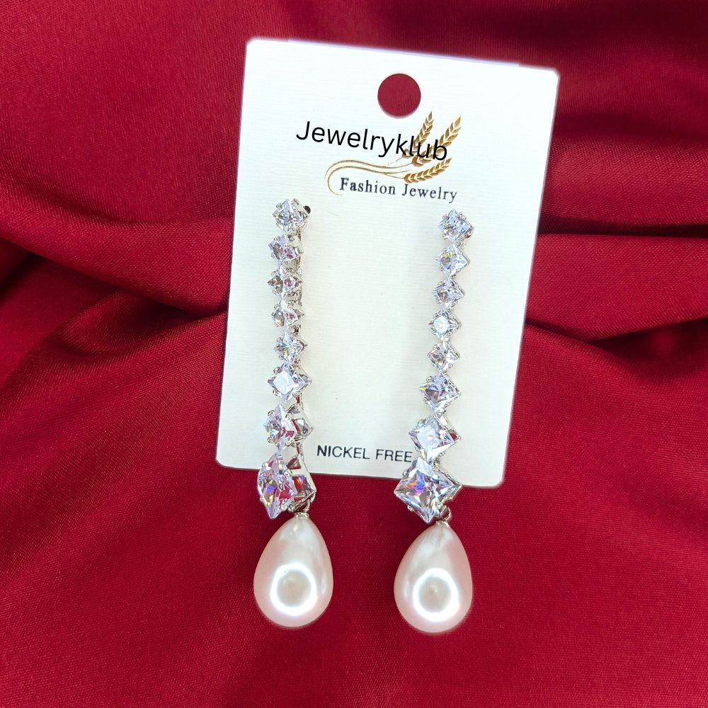 Elegant crystal drop earrings with pearl accents displayed on a Jewelryklub card against a red fabric background
